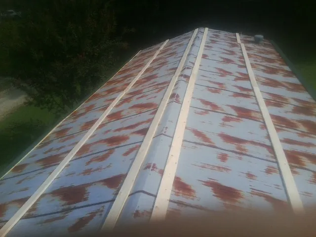 Rusted metal roof panels with new wood purlins before replacement — Storm Damage Roof Repair in Parrottsville by Roofing Brothers