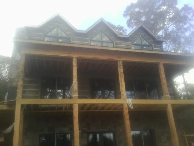 Dormers and porch framing on a large log home under construction — Roof Coating work by our crew in Parrottsville